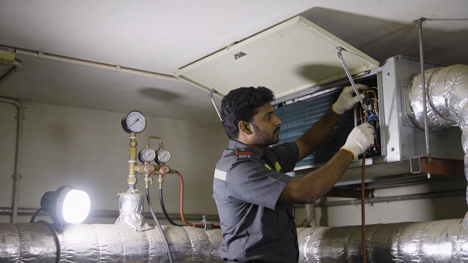 HVAC technician servicing an air handling unit